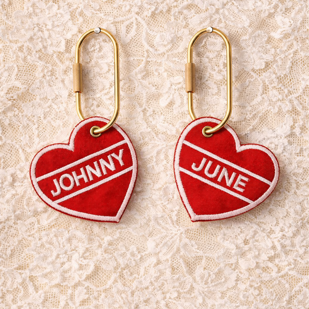 Red heart-shaped earrings with 'JOHNNY' and 'JUNE' text on a lace background