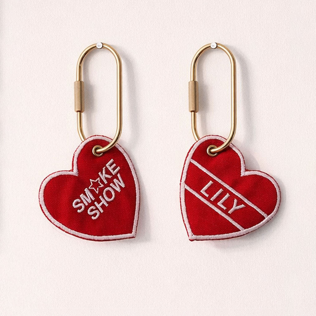 Red heart-shaped keychains with gold carabiners on a white background